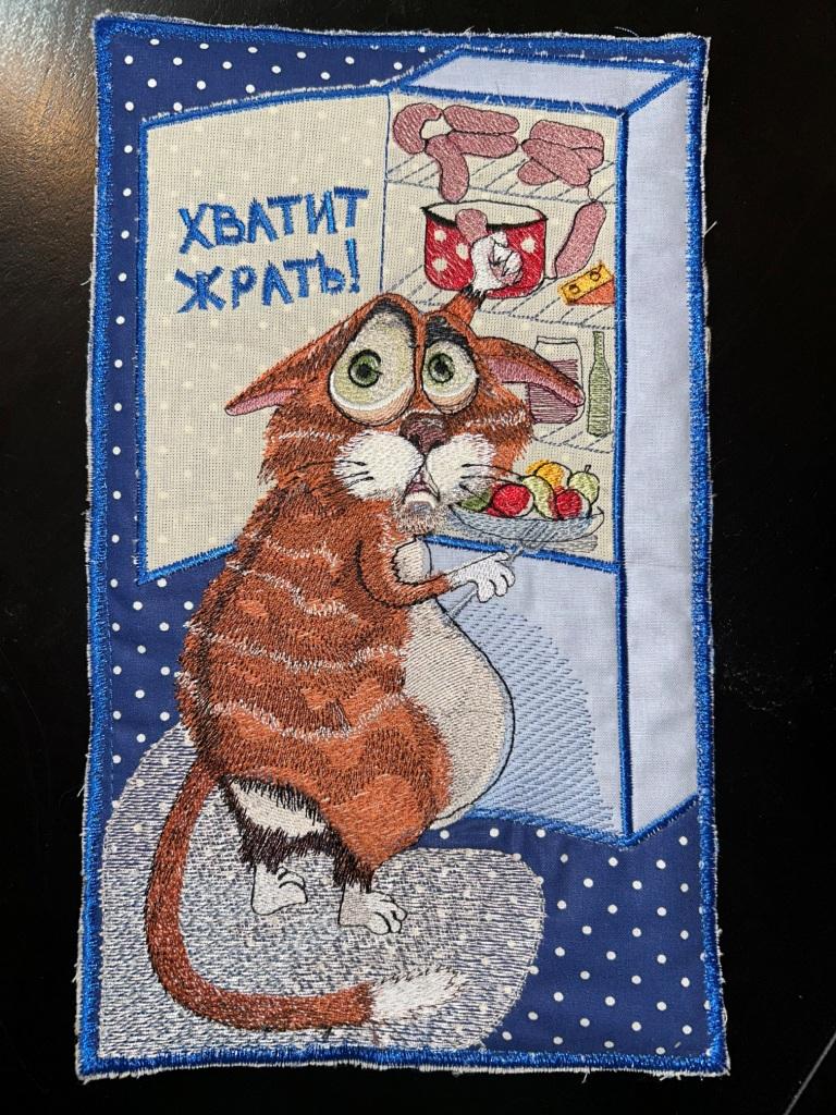 Вышивка гладью рыжего кота с огромными глазами у открытого холодильника с надписью «ХВАТИТ ЖРАТЬ!»
Фото вышитого дизайна
